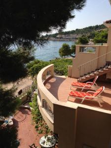 a deck with two chairs and a view of the water at Villa Favola in Primošten
