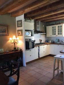 una cucina con armadi bianchi e un tavolo di LE CLOS DU GOLF a Dame-Marie-les-Bois