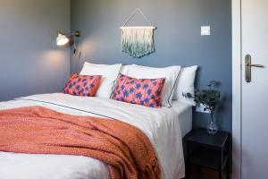 um quarto com uma cama com almofadas laranja e azul em Apartamento Coral em Denia