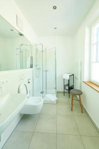 a white bathroom with a sink and a shower at Hotel Garni Goldammer in Dießen am Ammersee