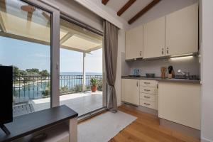 uma cozinha com armários brancos e uma grande janela em Beach house Blue Lagoon em Okrug Gornji