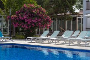 un grupo de tumbonas junto a la piscina en Aparthotel Vibra Club Maritim en San Antonio Bay