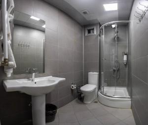 a bathroom with a sink and a shower and a toilet at Diplomat Suites in Baku