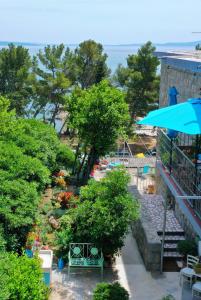 a view of a garden with a blue umbrella at Beachfront Apartment Mala Tereza in Split