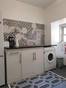 a kitchen with a washing machine and a washer at Casa do Má in Lisbon