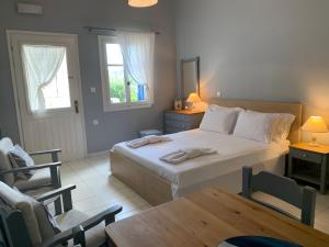 a bedroom with a bed and a table and a chair at Kiki Studios in Fiskardo