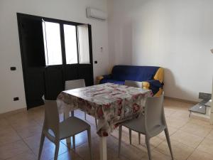 een eettafel met stoelen en een blauwe bank bij Indipendence's house in Ispica