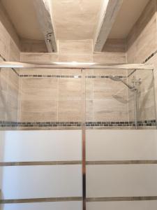 a shower with a glass door in a bathroom at Bois logis in Bléré