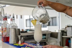a person pouring a drink into a glass at Apartamentos Vibra Jabeque Soul-3SUP in Ibiza Town