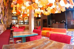 a restaurant with colorful chairs and tables and chandeliers at Generator Barcelona in Barcelona