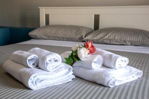 due asciugamani e un fiore su un letto di Guest House Nonnolorè a Agrigento