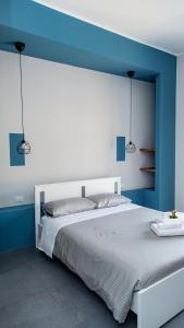 una camera da letto con un letto bianco e pareti blu di Guest House Nonnolorè a Agrigento