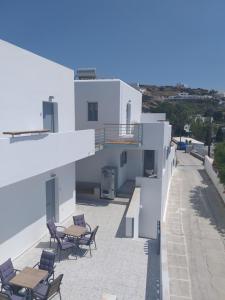 a balcony of a white building with chairs and tables at Drimoni Boutique in Ios Chora