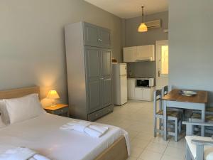 a bedroom with a bed and a table and a kitchen at Kiki Studios in Fiskardo