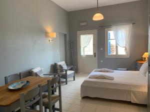 a bedroom with a bed and a table and a dining room at Kiki Studios in Fiskardo