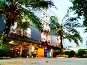 un hotel con palmeras delante en Beerapan Hotel, en Bangkok