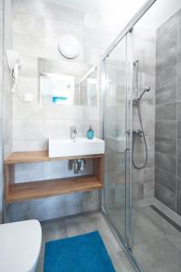 a bathroom with a sink and a shower at Dworek Karwia u Ewy Wiosenna 10 in Karwia