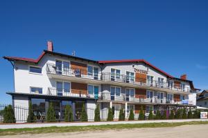 a hotel with balconies and a sign that reads hotel at Dworek Karwia u Ewy Wiosenna 10 in Karwia