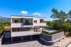 uma grande casa branca com piscina em Villa Tela em Kučiće