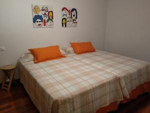 a bedroom with a bed with orange pillows on it at Apartamento en Primera Linea in Porto do Son