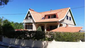 una casa con techo rojo y valla en Villa Ana, en Nazaré