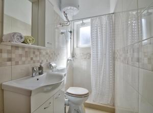 セニにあるApartment Forticaのトイレと洗面台を備えた白いバスルーム