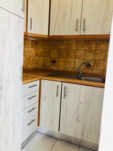 a kitchen with white cabinets and a sink at Sofimel Apartment in Skala Sotiros +20 photos