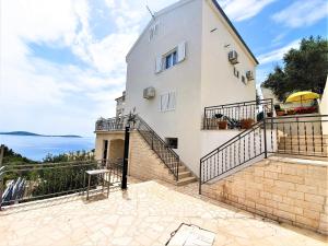 a house with a balcony with a view of the ocean at Apartments T&M in Vinišće