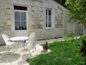 a patio with a table and chairs in front of a building at les simons in Soubran