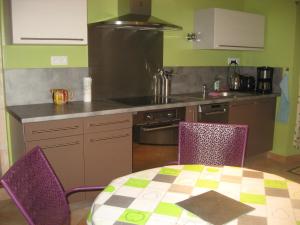 a kitchen with a table and chairs and a kitchen with a stove at les simons in Soubran