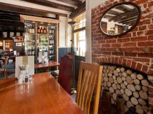 a dining room with a wooden table and a brick wall at The Fox by Greene King Inns in Bury Saint Edmunds +23 photos