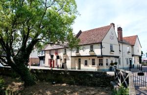 a white building with a tree in front of it at The Fox by Greene King Inns in Bury Saint Edmunds