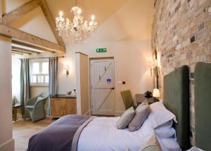 a bedroom with a bed and a brick wall at The Fox by Greene King Inns in Bury Saint Edmunds