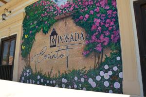 un cartello sul lato di un edificio con fiori di Posada Corinto Paipa a Paipa
