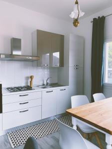 a kitchen with white cabinets and a wooden table at Il Cortile in Domus de Maria