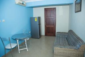 una sala da pranzo con tavolo e frigorifero di Ridge Over Suite a Accra