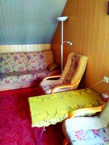 a room with two beds and a table and a lamp at APARTAMENT ZACISZE in Grzybowo