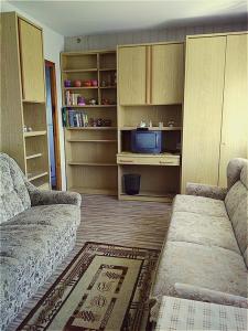 a living room with two couches and a tv at APARTAMENT ZACISZE in Grzybowo