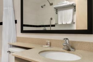a bathroom with a sink and a mirror at Days Inn & Suites by Wyndham Moncton in Moncton