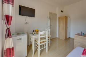 a room with a table and chairs and a television at Apartmani Bozinovic in Herceg-Novi