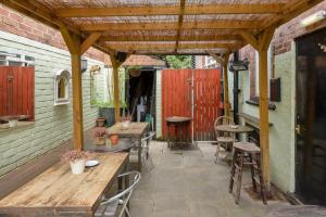 patio ze stołami i krzesłami oraz drewnianą pergolą w obiekcie Golden Eagle w mieście Chester