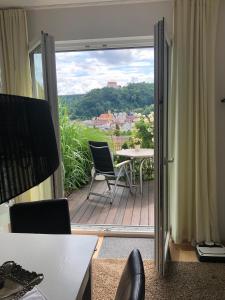 Habitación con balcón con mesa y sillas. en Ferienwohnung Burgenblick mit Blick auf Riedenburg, en Riedenburg