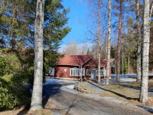 ein rotes Haus im Wald mit Bäumen in der Unterkunft Luontoleirikeskus Lankari in Seinäjoki
