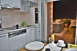a kitchen with a table with plates on it at Pool, Sauna, Jacuzzi with Sea view - Apartment Josipa in Podstrana
