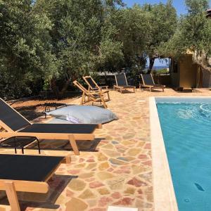 a swimming pool with lounge chairs next to a swimming pool at Villa Gaia in Monemvasia