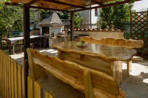 a wooden table and bench in a backyard with a grill at Apartment Erceg in Poreč