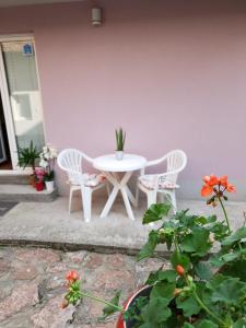 a white table and chairs on a patio with flowers at Vila Stefanovic in Soko Banja