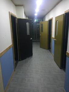 an empty hallway with doors and a hallway with a corridorngthngthngthngthngth at The Core Albergue in Seoul