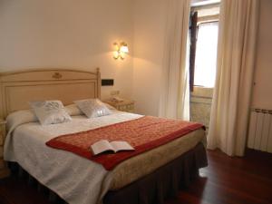 a bedroom with a bed with two books on it at Pazo Carrasqueira in Ribadumia