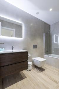 a bathroom with a sink and a toilet and a shower at Travel Hábitat Ayuntamiento in Valencia